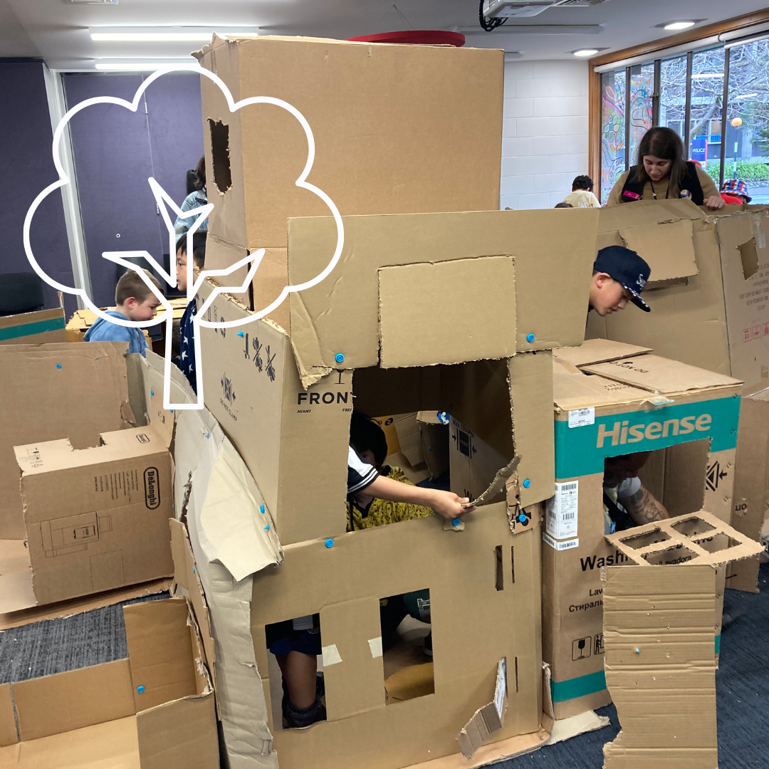 Children building with cardboard with a white stylised tree