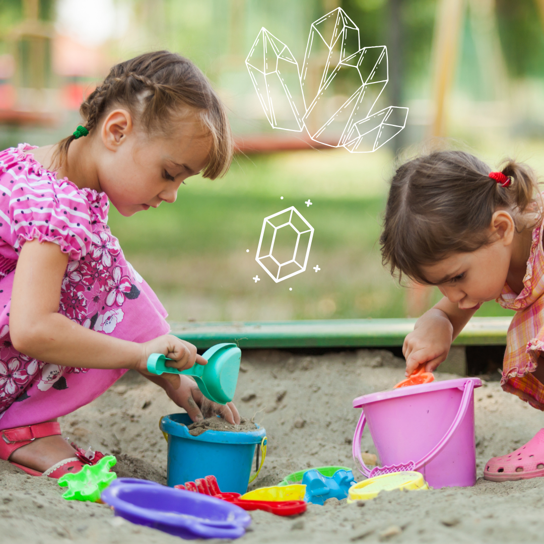 Two children digging in sand with a geode and gem